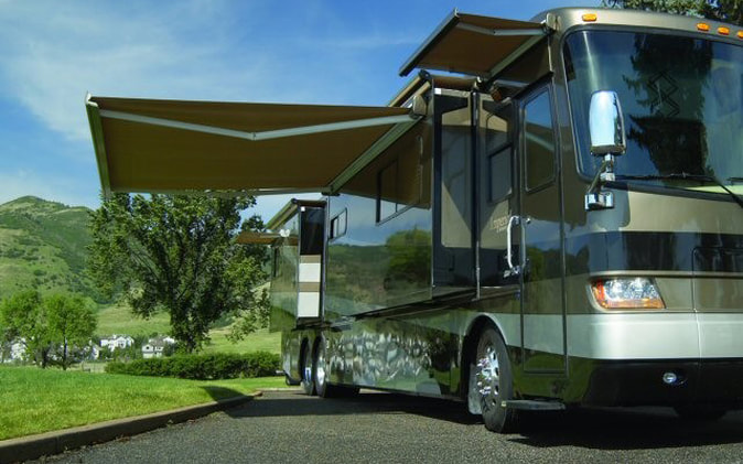 A RV with a patio and window awning extended