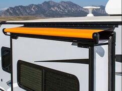 A RV with an orange alpine slideout cover 