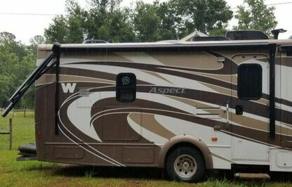 The side of a brown RV with a broken arm