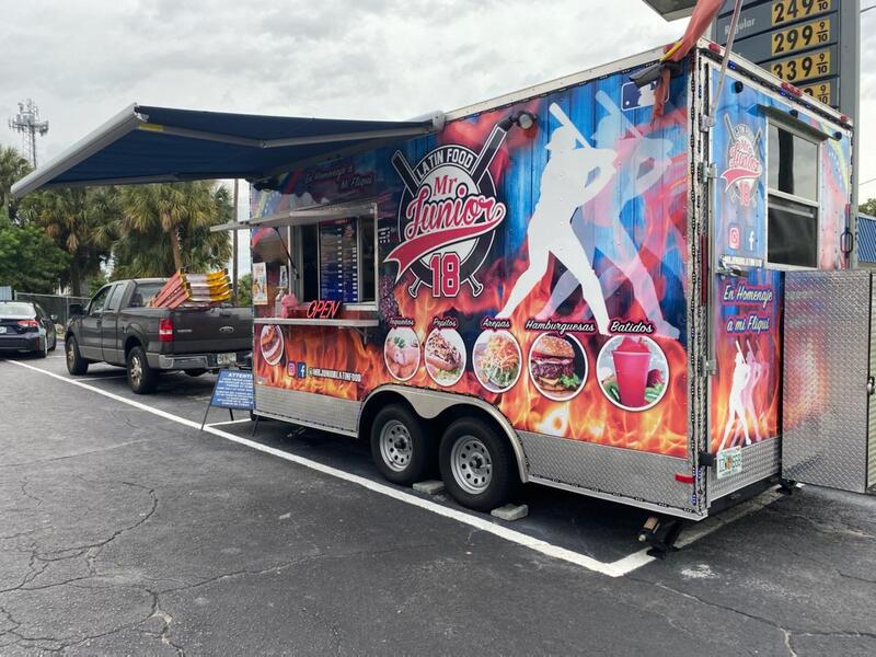 A baseball themed food truck in a parking lot with vibrant colors and an extended custom awning