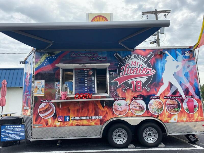 A baseball themed food truck in a parking lot with vibrant colors and an extended custom awning